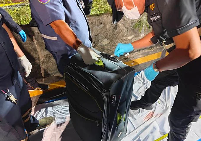 Agentes incepccionando la maleta donde el turista australiano guardó el cadáver de la joven tailandesa asesinada 